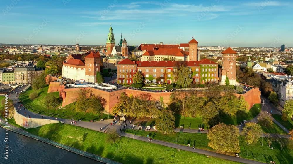 Krakow, Poland. Wawel royal Castle and Cathedral, Vistula River with tourist boats, park, boulevards, promenades with walking people and bikers. Aerial 4K panning video in autumn in sunset ligh Krakow, Poland. Wawel royal Castle and Cathedral, Vistula River with tourist boats, park, boulevards, promenades with walking people and bikers. Aerial 4K panning video in autumn in sunset ligh