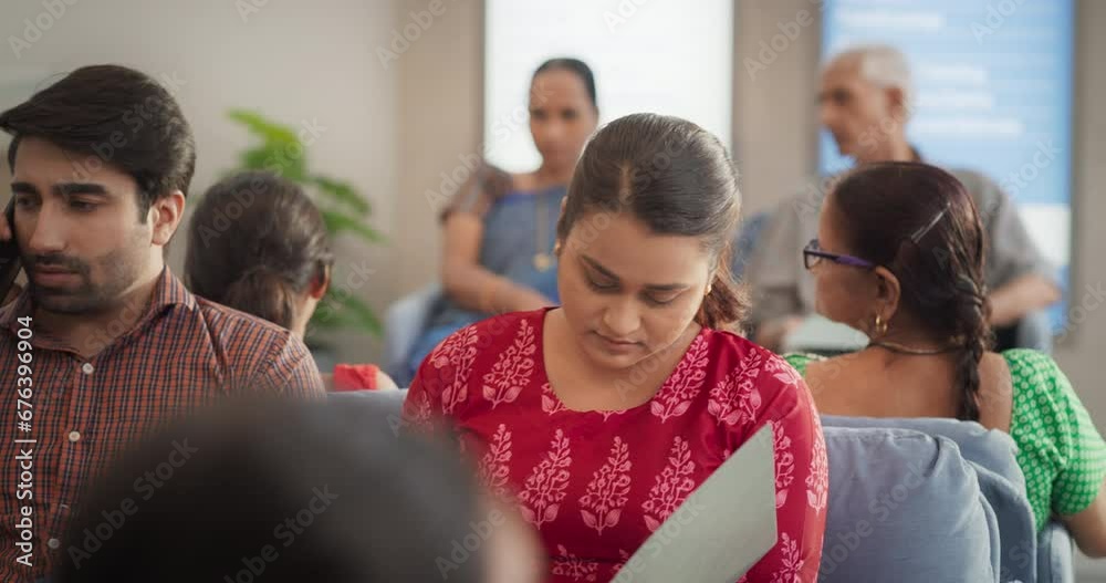 Dolly Shot Showing Portraits of Patients Waiting in Reception Hall in a Hospital. Indian Diverse Group Talking, Checking Medical Analysis Report in a Busy Local Health Clinic During the Day