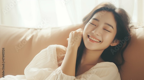 Smile asian woman lay on sofa, soft light morning