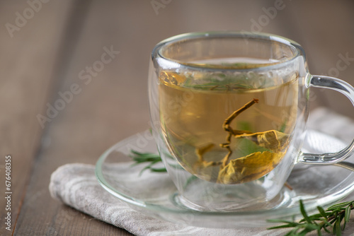 hot tea on wood table. Transparent cup of freshly brewed tea on wood table