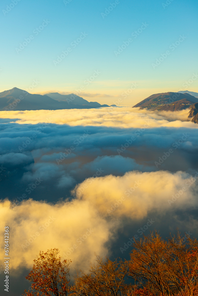 Mountain Peak Above Cloudscape with Sunlight and Clear Sky in Lugano, Ticino in Switzerland.