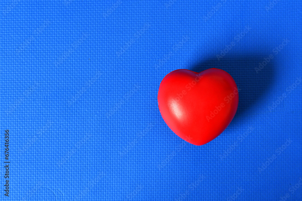 Corazón rojo sobre fondo azul. Espacio para texto al lado izquierdo.