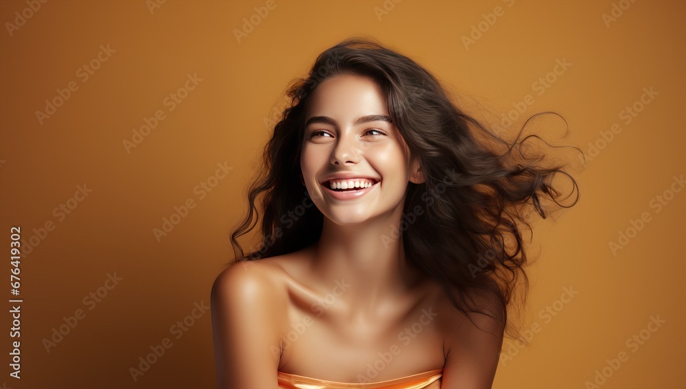 young woman with flying hair on yellow background