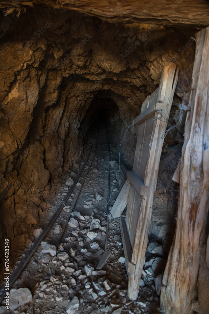 Old metal rail tracks and mining entrance at Eureka Gold Mine in the desert, Death Valley National Park, California