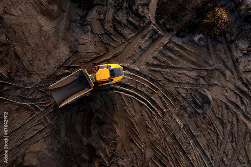 Aerial view above an earth mover truck on a muddy construction site
