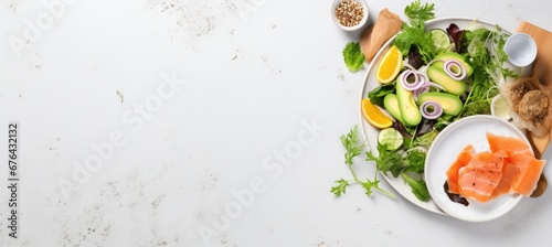 Fresh salmon fillets on plate with lemon and green lettuce leaves and spices, isolated on white background