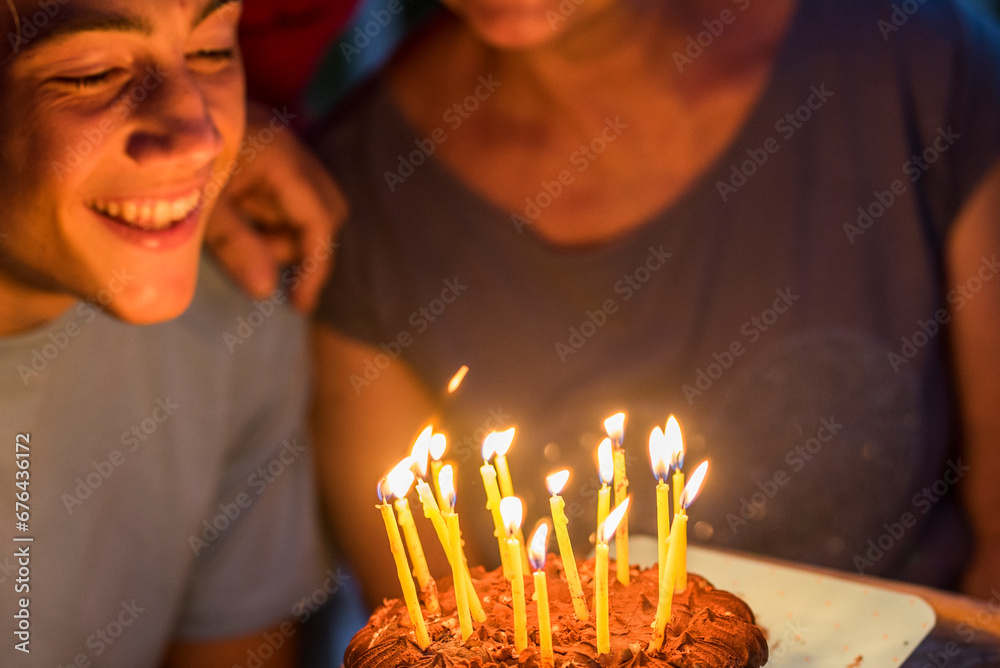 Close up of night party and birthday cake with candles. Young teenager boy and grandfathers enjoy and celebrate together with happiness. Age and aging generations concept event Close up of night party and birthday cake with candles. Young teenager boy and grandfathers enjoy and celebrate together with happiness. Age and aging generations concept event