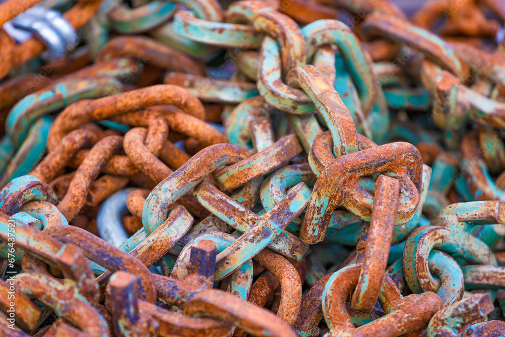 Close up of a pile of chain links corroding.