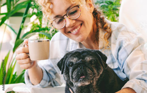 Love people and dog animal concept with happy adult caucasian woman and black old pug hugging and loving with tendernes together. Best friends forever concept photo