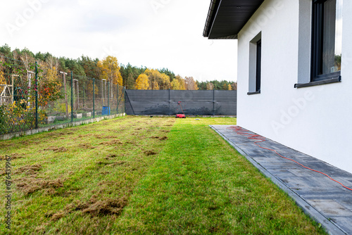 Scarifying the lawn before the winter season using an electric scarifier. photo