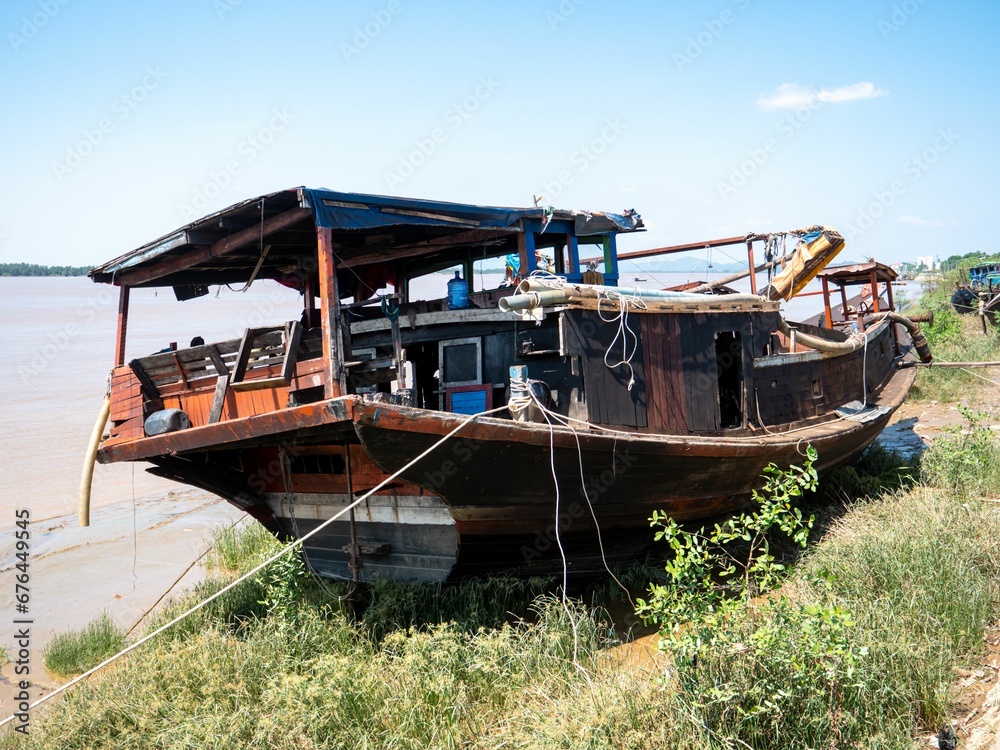 Wreck of a fishing boat on the shore of a river Wreck of a fishing boat on the shore of a river