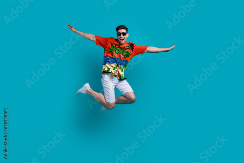 Full body photo picture of funky flying air plane wings hands guy brunet wear sunglasses travel abroad isolated on blue color background © deagreez