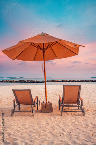 Romantic beach landscape. Couple chairs umbrella sunset sunrise colorful sky clouds. Dream beach honeymoon vacation. Best love destination travels. Amazing leisure relax wellbeing idyllic sunlight