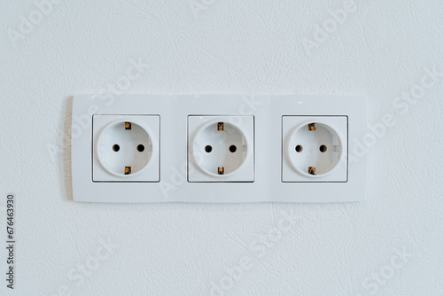 Three sockets in the wall are shot close-up, the power output in the home room.