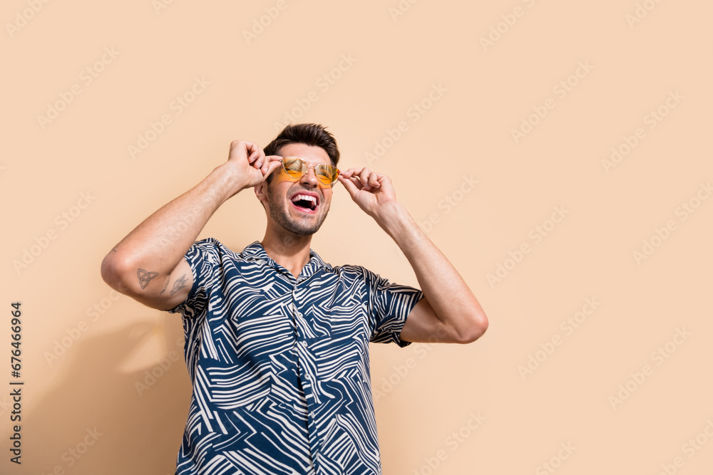 Photo of positive active energetic man dressed trendy clothes looking empty space special offer banner isolated on beige color background Photo of positive active energetic man dressed trendy clothes looking empty space special offer banner isolated on beige color background
