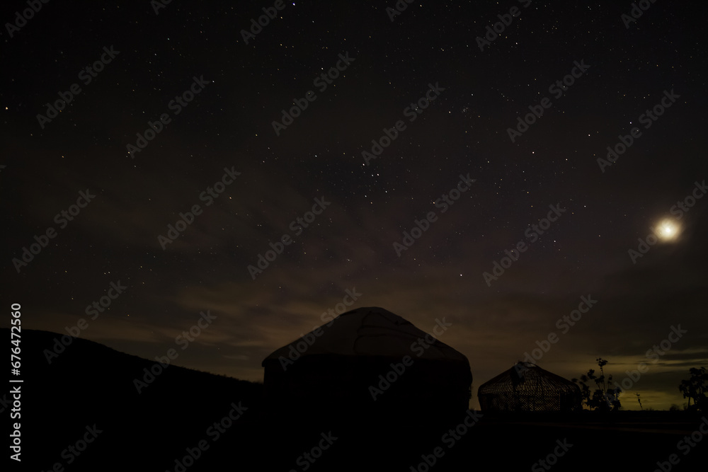 Yurts in the darkness of the night against the backdrop of the starry sky in the desert Yurts in the darkness of the night against the backdrop of the starry sky in the desert