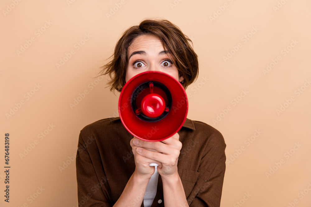 Obraz premium Photo of funky impressed lady wear brown shirt shouting loud speaker isolated beige color background