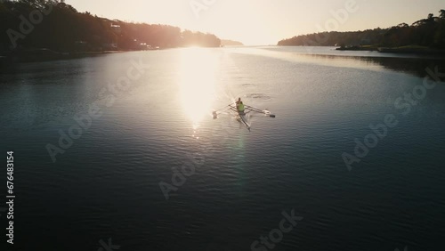 Aerial view Sports rowing boat with two women rowing on calm water at sunrise. photo