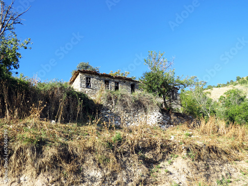 Abandoned ruined house in Palaio Kostarazi Martyric Village in Northern Greece photo