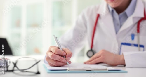 Hands of therapist make notes with pen in medical record photo