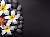 SPA smooth black stones on a black volcanic sand and beautiful flowers background. Copy space for text, banner.