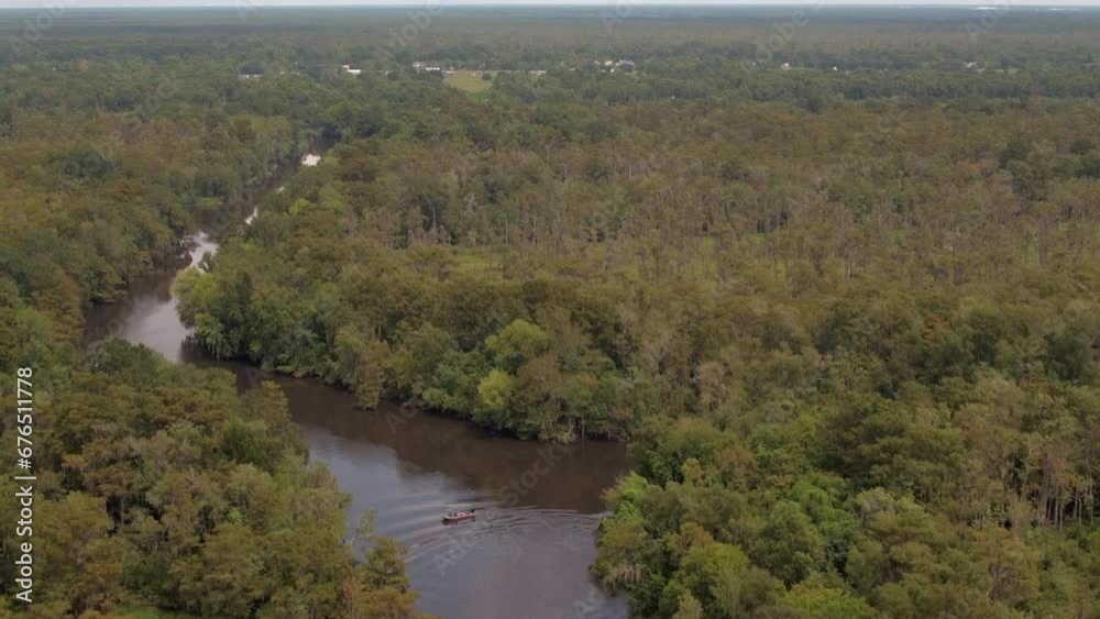 Aerial Backward Tilt Down Shot Of Nautical Vessel In Atchafalaya River Amidst Green Trees On Landscapes - Bayou, Louisiana Aerial Backward Tilt Down Shot Of Nautical Vessel In Atchafalaya River Amidst Green Trees On Landscapes - Bayou, Louisiana