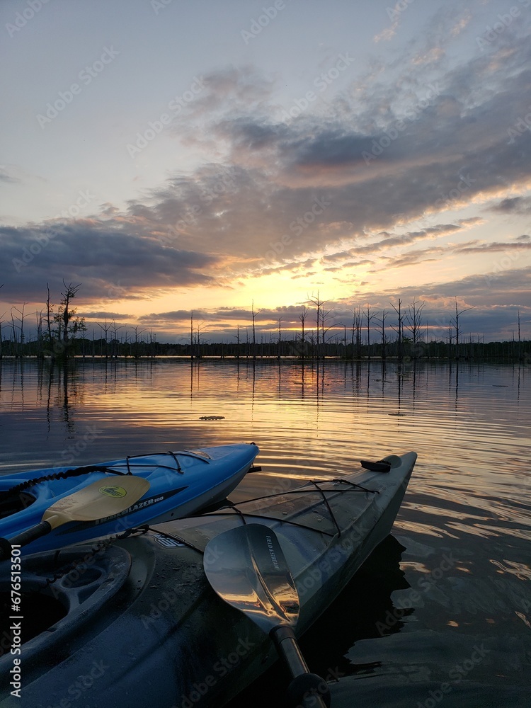 Obraz premium Kayaks observing the sun set on a Louisiana bayou in fall.
