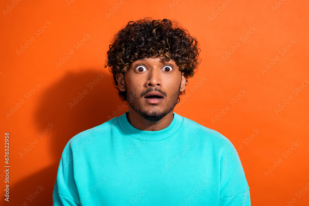 Obraz premium Portrait of speechless shocked young man open mouth staring cant believe isolated on orange color background