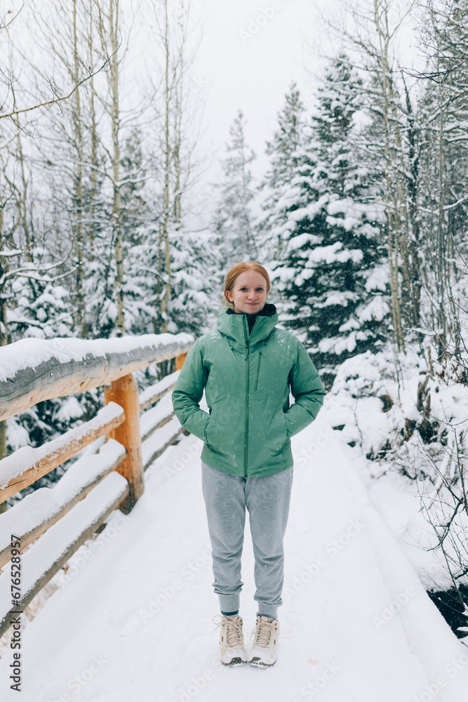Female hiker walking through the snow woods and mountains Female hiker walking through the snow woods and mountains
