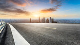panoramic city skyline and buildings with empty asphalt road at sunset