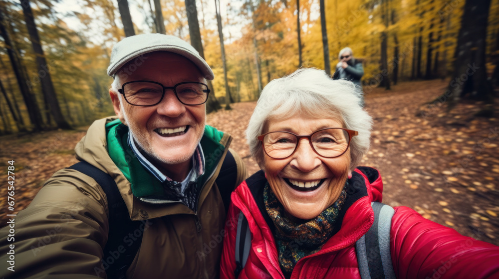 POV portrait of active senior couple looking at camera and smiling while taking selfie photo during hike in autumn forest, copy space POV portrait of active senior couple looking at camera and smiling while taking selfie photo during hike in autumn forest, copy space