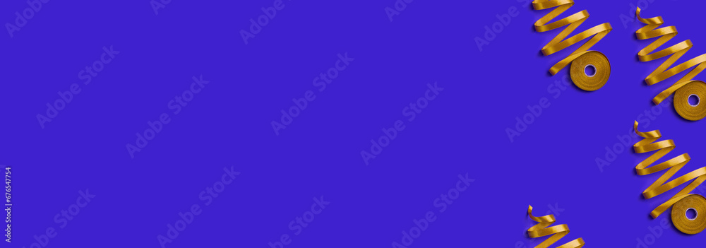 Obraz premium New Year banner with concept of Christmas trees made of golden ribbon on blue background. Top view