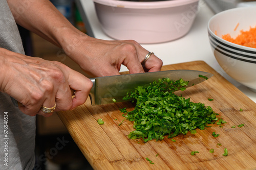 woman cutting parsley on a cutting board in the kitchen 2