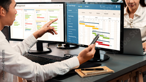 Project management team coordinating and update project planned schedule on computer using Gantt chart software in office. Business people planning time and deadline for company task. Trailblazing