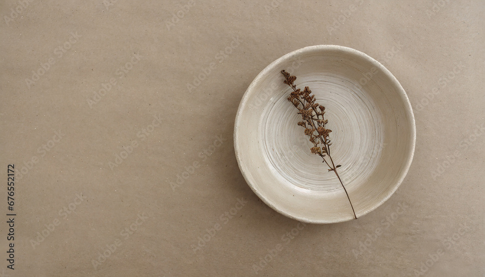 Minimalist ceramic bowl with dry plant over kraft paper background. Copy space, flat lay. Minimalist ceramic bowl with dry plant over kraft paper background. Copy space, flat lay.