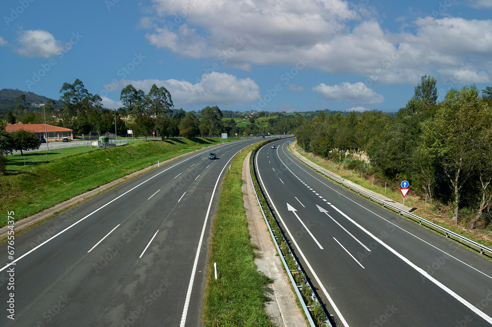 open curve on the A8 Cantabrian highway with three lanes in each direction seen from the pedestrian walkway