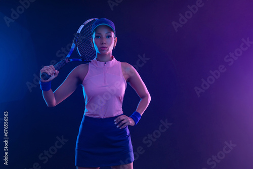 Tennis player woman with racket on tournament. Girl athlete with tenis racket on court with neon colors. Sport concept. Download a high quality photo for design of a sports app or tour events. photo