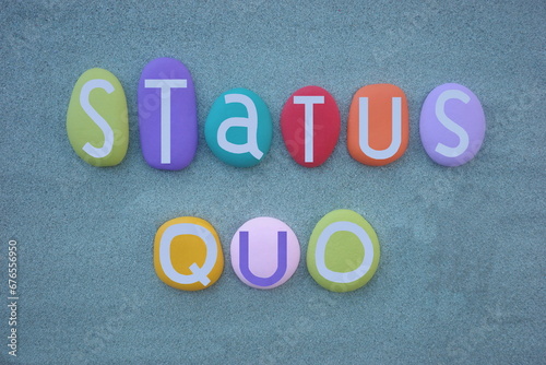 Status Quo, the state in which, latin phrase that is commonly used to indicate the same situation without changes, text composed with multi colored stone letters over green sand