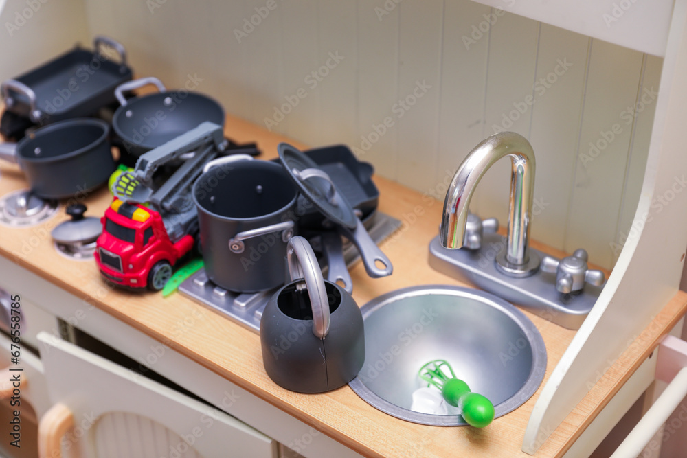 Naklejka premium Children's colorful toys, tiny legs, and building blocks scattered on the floor, a playful scene of early childhood development