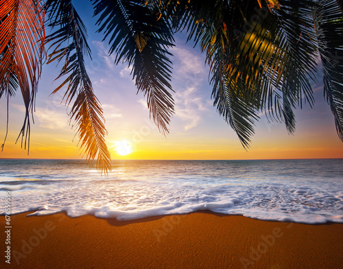 Beautiful tropical beach and leaves of coconut palm trees at sun
