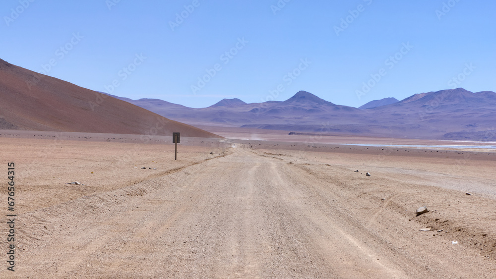 Bolivia, Salvador Dali Desert. Avoroa Nationa Park,  A road leading through the desert towards the mountains.
