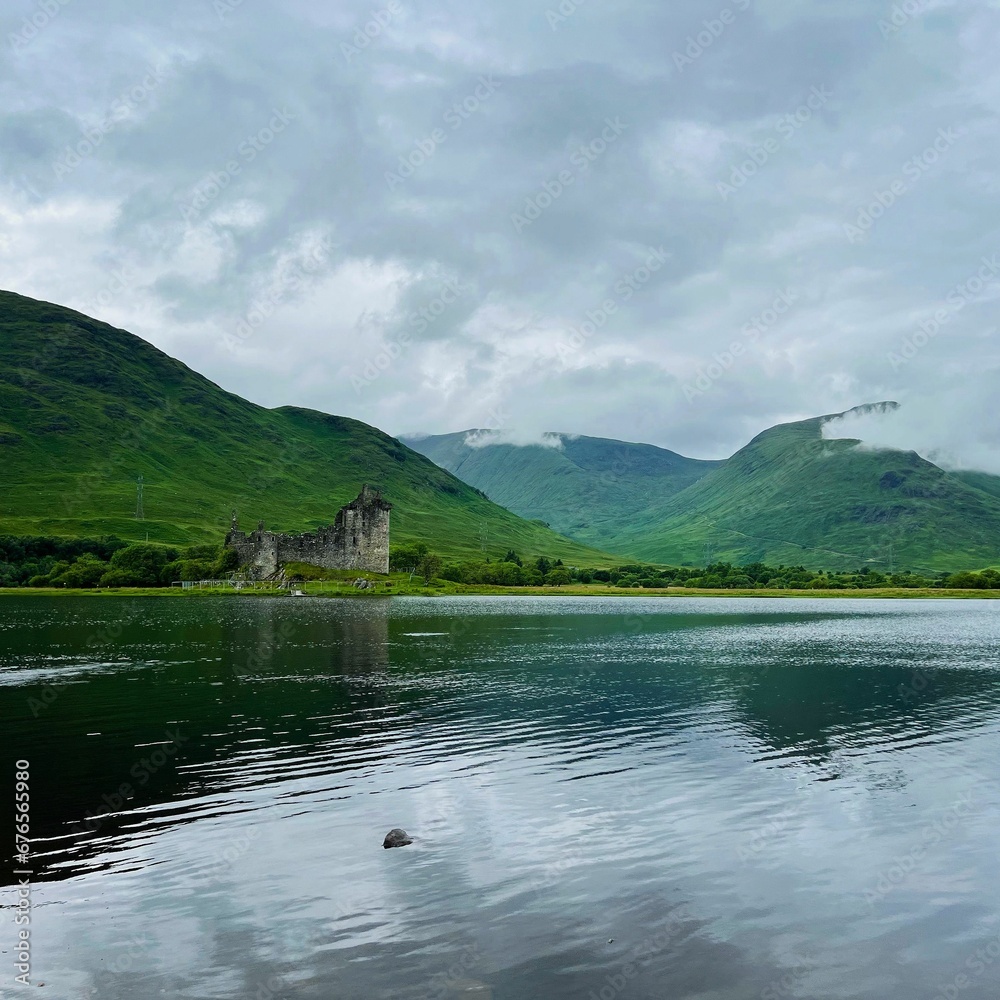 Distant shot of the ruins of the medieval castle of Kilchurn in front of a lake in Scotland