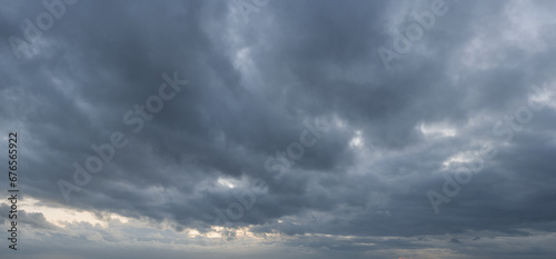 Panorama of a moody and wild cloudscape during blue hour after sunset