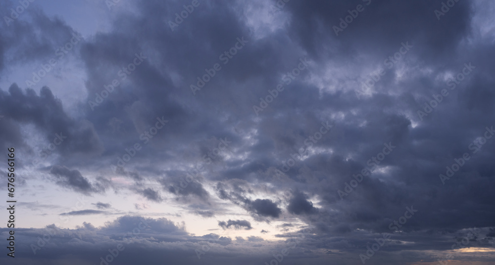 Panorama of a moody and wild cloudscape during blue hour after sunset Panorama of a moody and wild cloudscape during blue hour after sunset