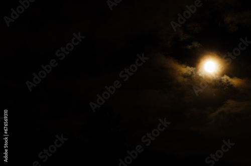 noc, księżyc na tle chmur i czarnego nieba