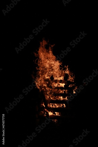 Vertical shot of a bonfire outdoors at night - perfect for wallpapers © Wirestock