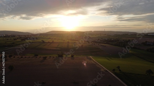 Drone view of a field covered in greenery during the sunset in the evening in the countryside