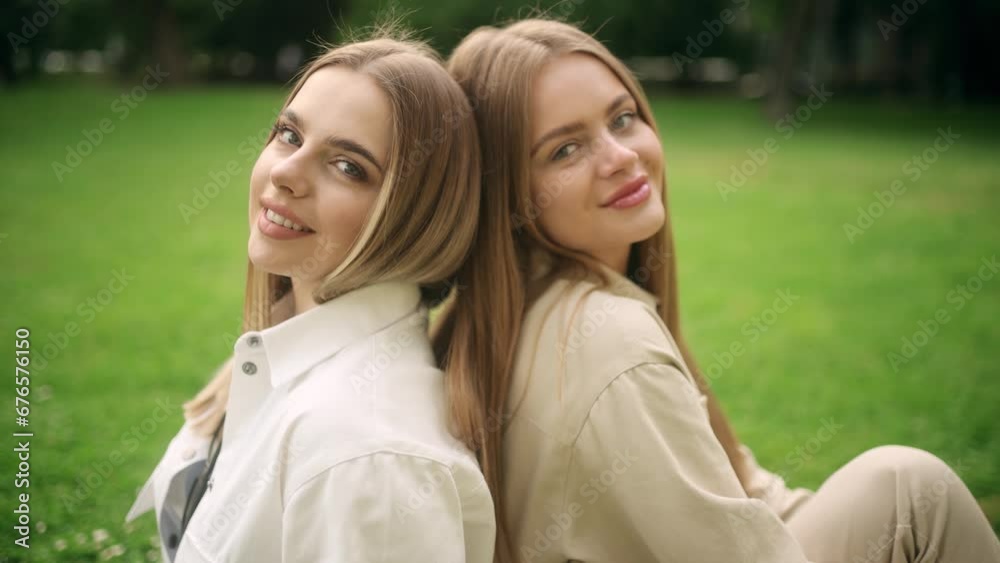 Calm young women friends looking at the camera relaxing reducing stress after work at park Successful beautiful females resting for peaceful mind outdoors Calm young women friends looking at the camera relaxing reducing stress after work at park Successful beautiful females resting for peaceful mind outdoors