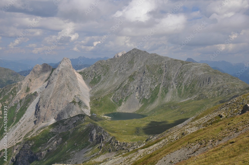 Beautiful landscape of big mountains of the Alps in Italy under the cloudy sky during the daytime Beautiful landscape of big mountains of the Alps in Italy under the cloudy sky during the daytime