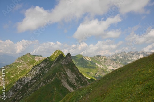 Mesmerizing landscape of grass mountains on a sunny day and under a blue sky